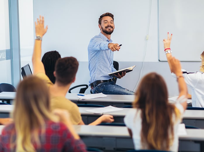 Male School teacher in class with pupils