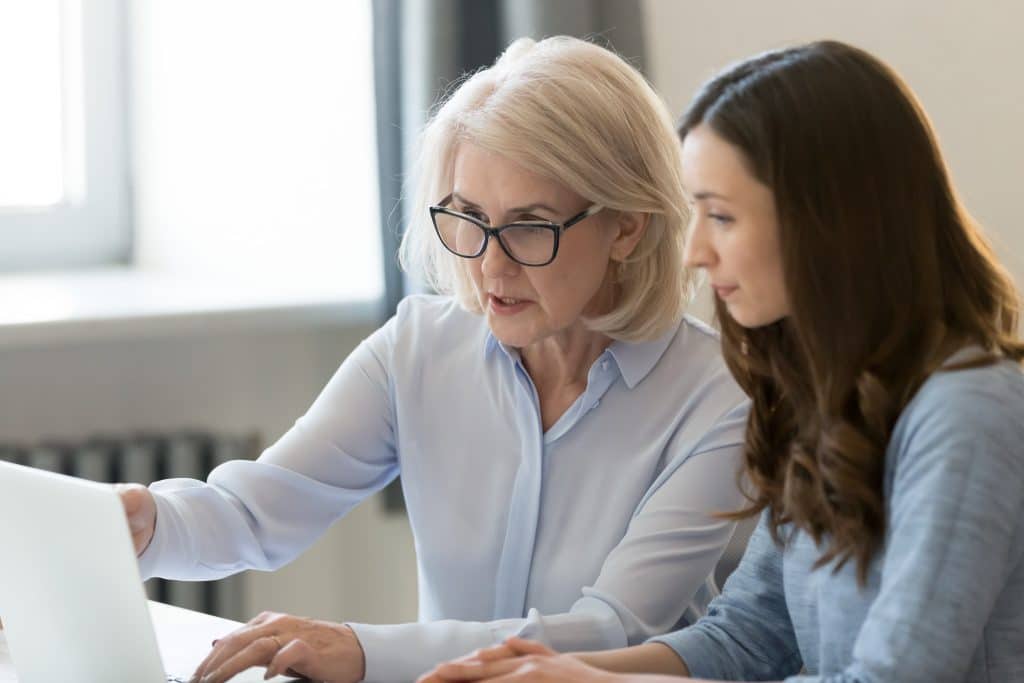 Education consultant working with school staff pointing at laptop