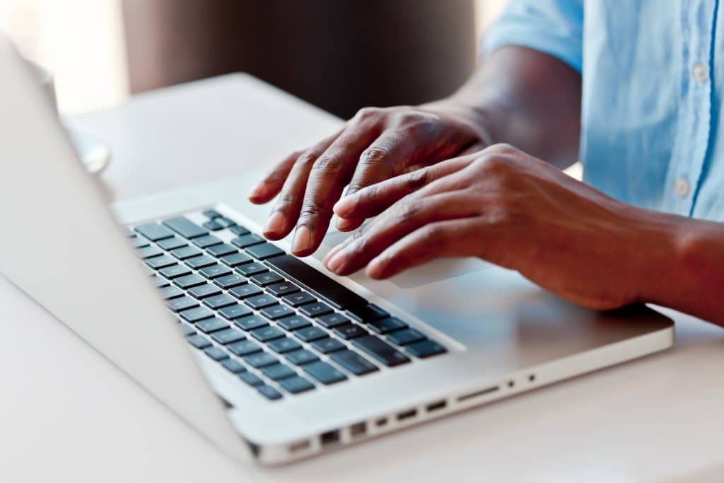 Male hands typing on a laptop