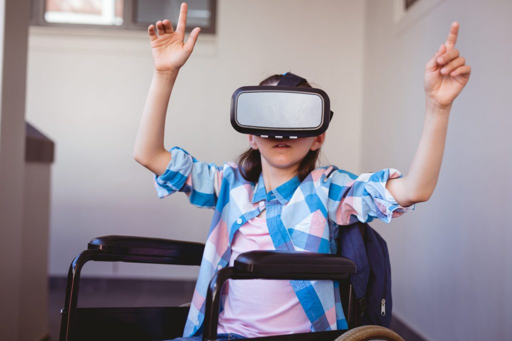 Schoolgirl in wheelchair using VR headset