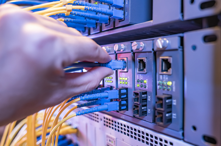 IT Technician plugging cables into a server.